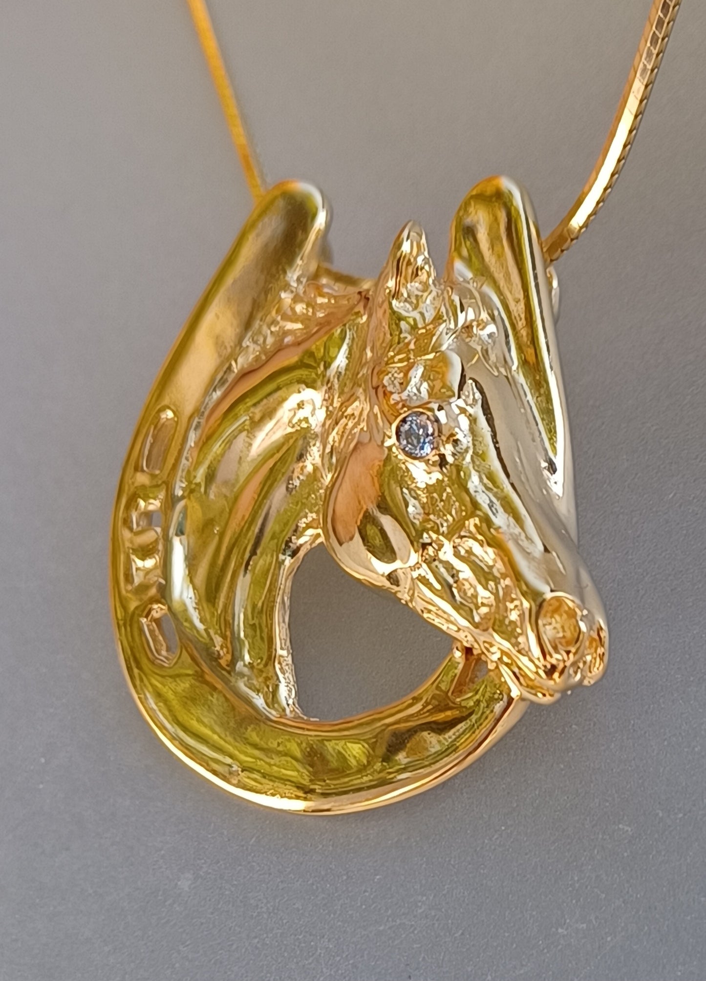 Horse in horseshoe pendant with Peridot stone eye. Artisan HEAVY gold plated. Forge Hill Sculpture jewelry
