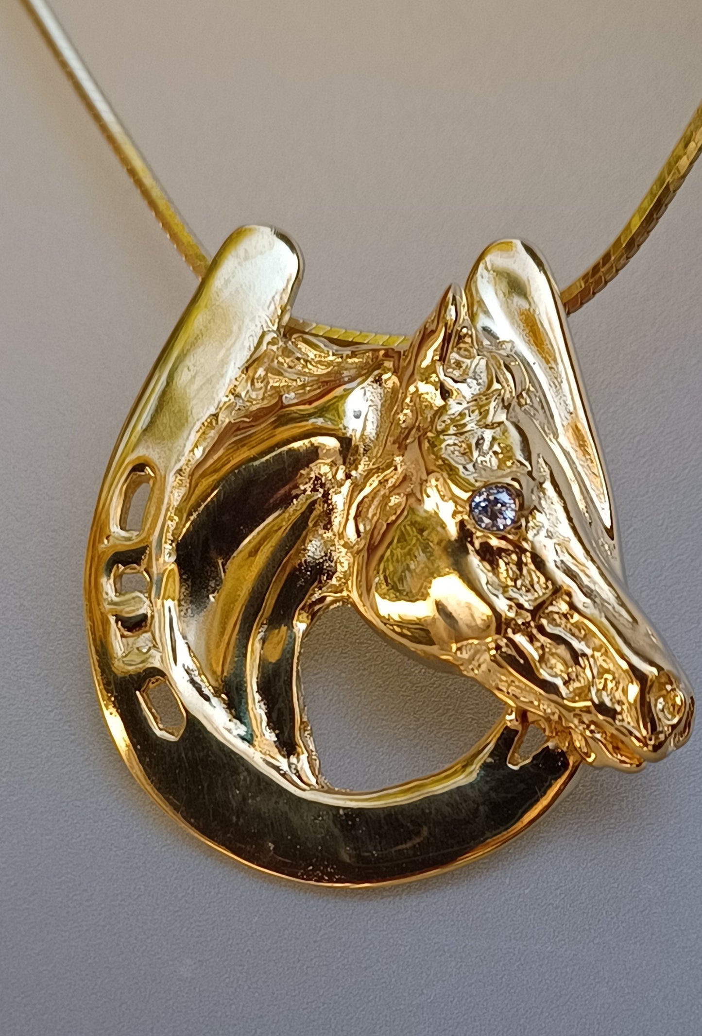 Horse in horseshoe pendant with Peridot stone eye. Artisan HEAVY gold plated. Forge Hill Sculpture jewelry